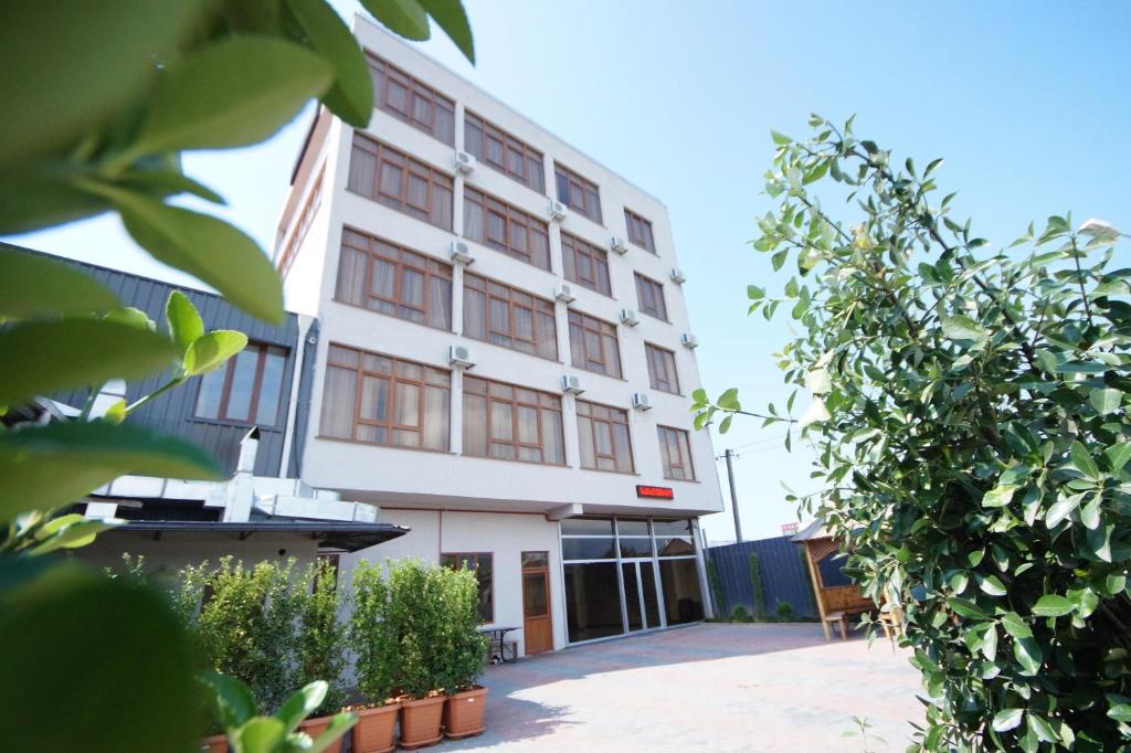 un edificio blanco con ventanas y plantas delante de él en Hotel 725 en Batumi