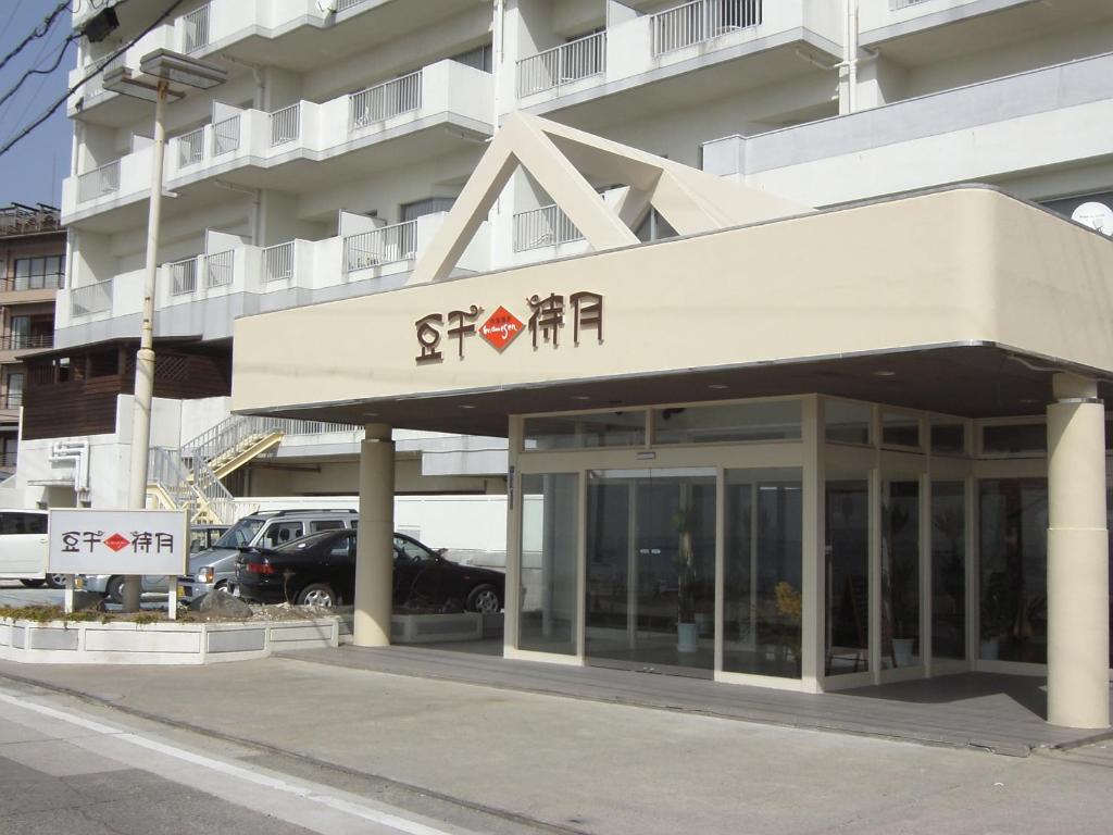 a building with a sign on the front of it at Mamesentaigetsu in Minamichita