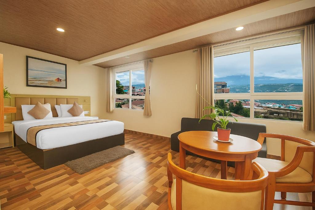 a hotel room with a bed and a table and chairs at TVD Hotel Polaris Gangtok Near MG Marg in Gangtok