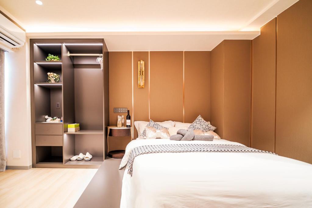 1 dormitorio con cama blanca y paredes marrones en 三ノ輪 吉原, en Tokio
