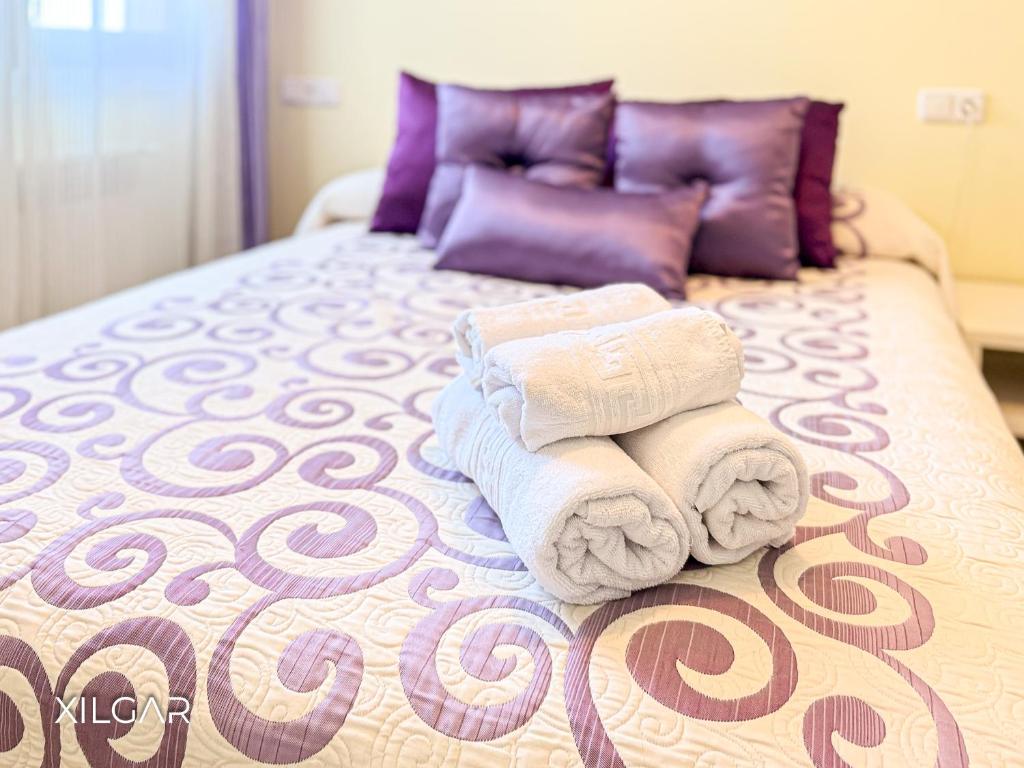 a pile of towels sitting on top of a bed at Xilgar - O Vimbieiro Chalet in Sanxenxo