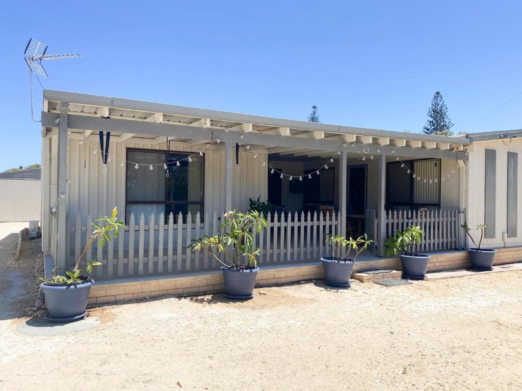 a small house with potted plants in front of it at Ocean Spray in Lancelin
