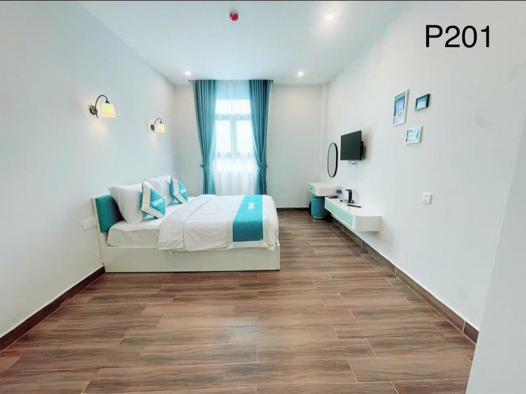 フーコックにあるWin House Hotelの白いベッドルーム(ベッド1台、テレビ付)
