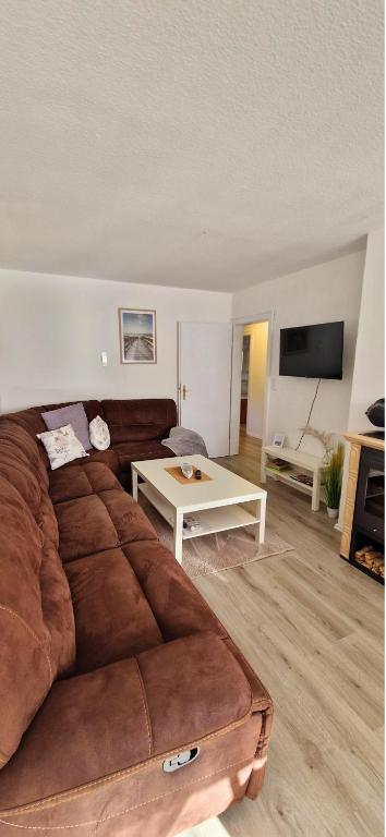 a living room with a brown couch and a table at Seeromantik in Amelinghausen
