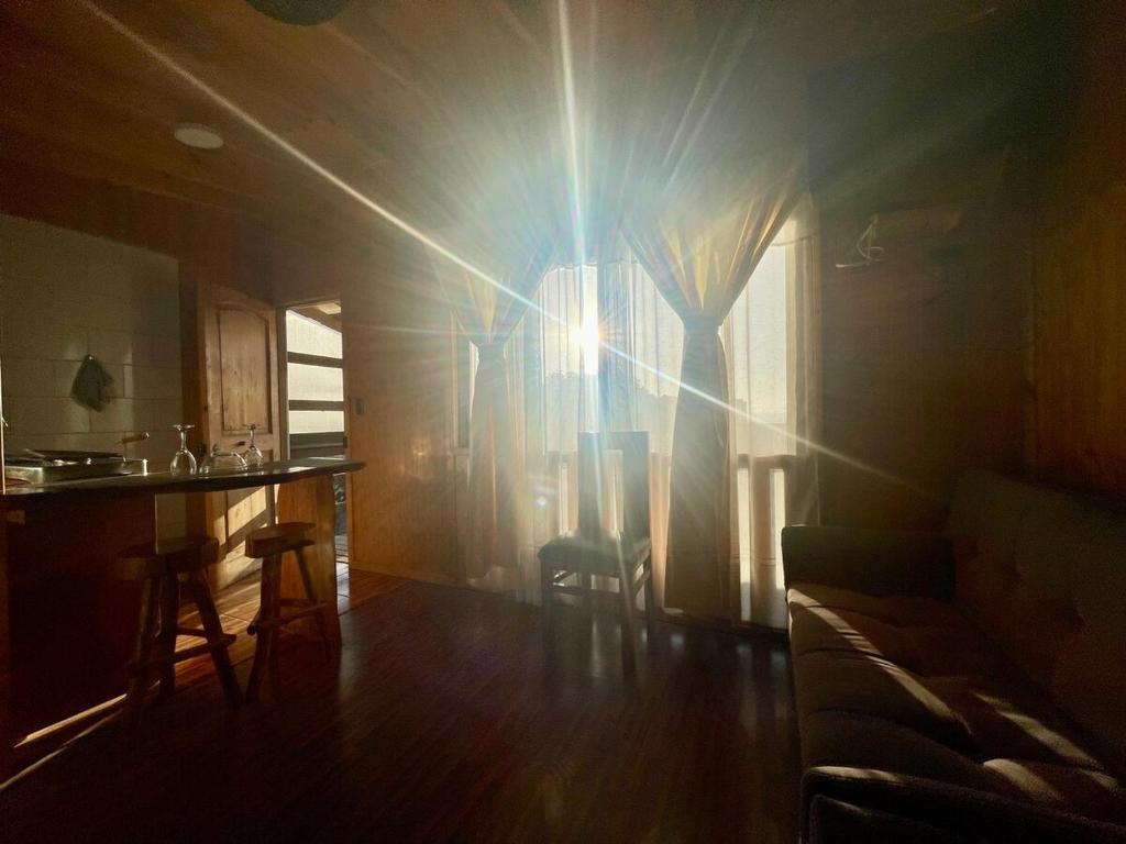 a sun shining through a window in a room at Apartamento en Playa Hermosa, Pichilemu - Cabañas Parova in Pichilemu
