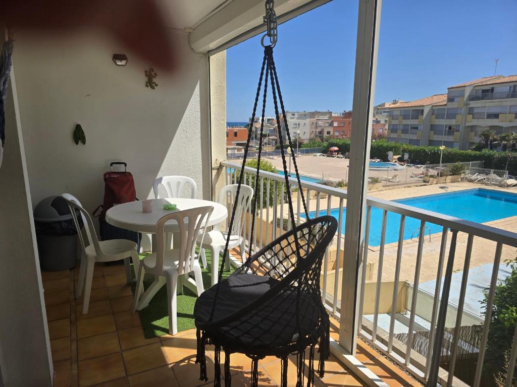 a balcony with a table and chairs and a pool at Apartment with pool included in Agde