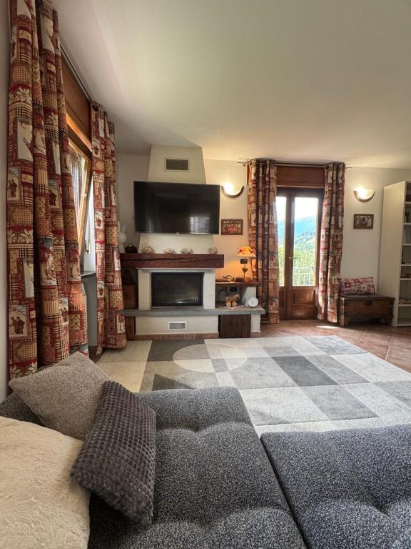 Una sala de estar con un sofá y una chimenea. en HabitAlp360, en Roisan