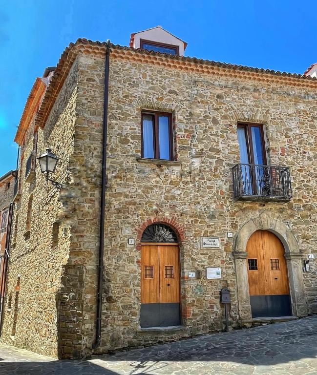 an old stone building with two doors and a balcony at Palazzetto Longobardi in Ogliastro Cilento
