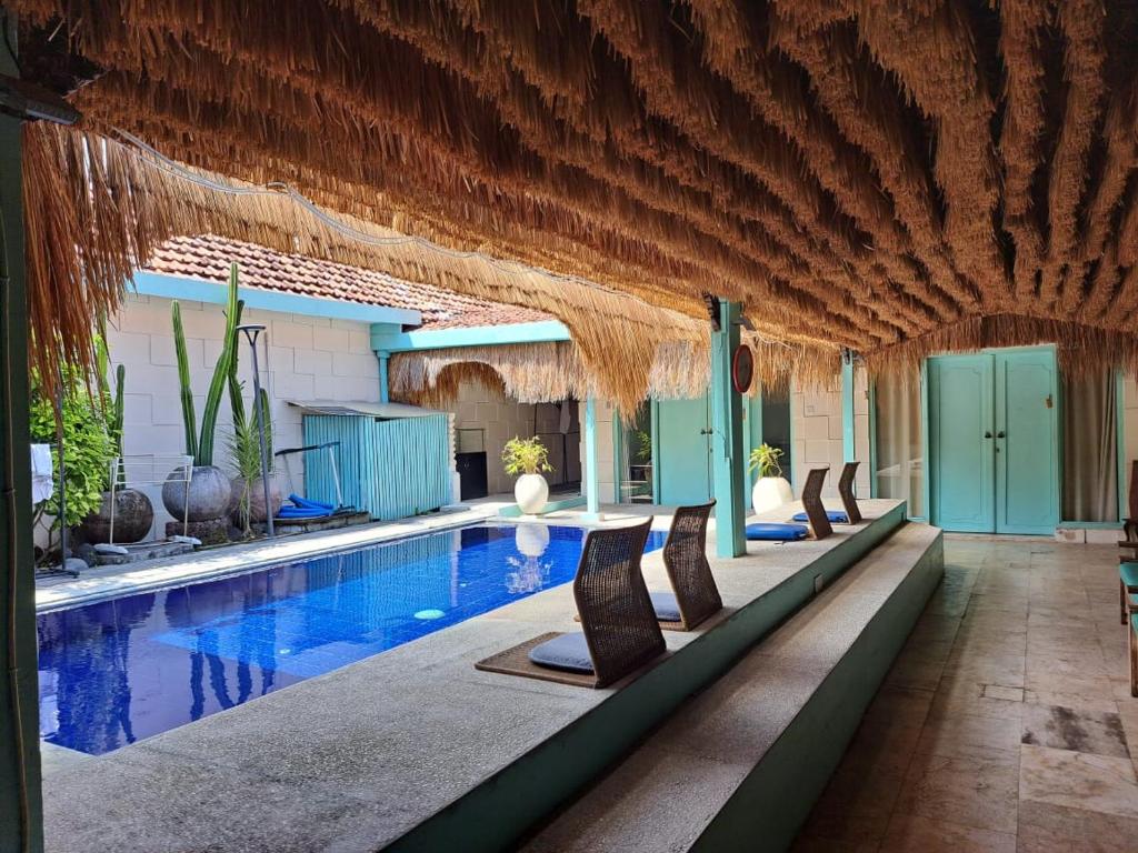a pool with a row of chairs next to it at Lavender Villa 7 Moon House in Kuta