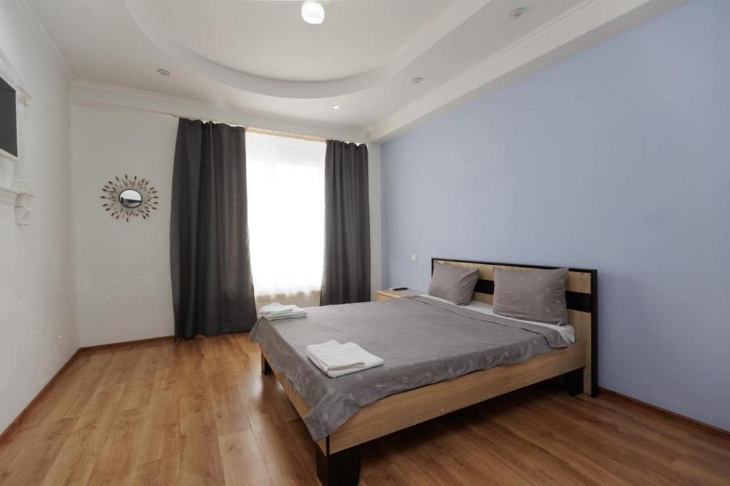 a bedroom with a bed and a large window at Apartament confortabil Chișinău in Chişinău