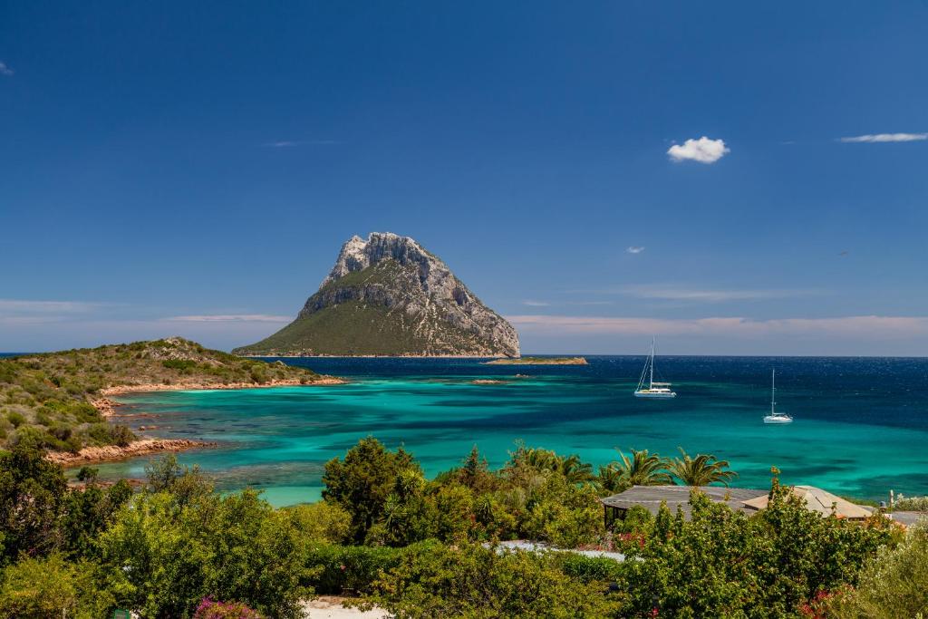 a view of a tropical island with boats in the water at Hotel Don Diego in Porto San Paolo