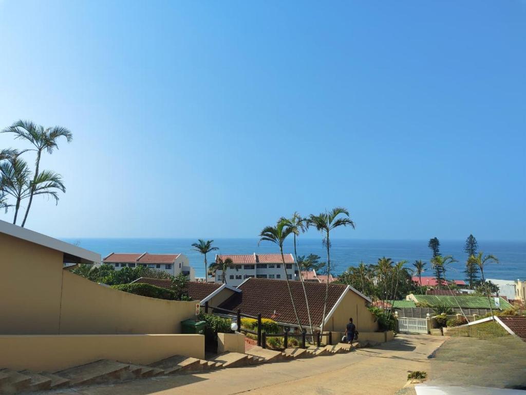 a view of a beach with palm trees and the ocean at Shaka's Rock Sea Vista - 17 Siesta in Ballito