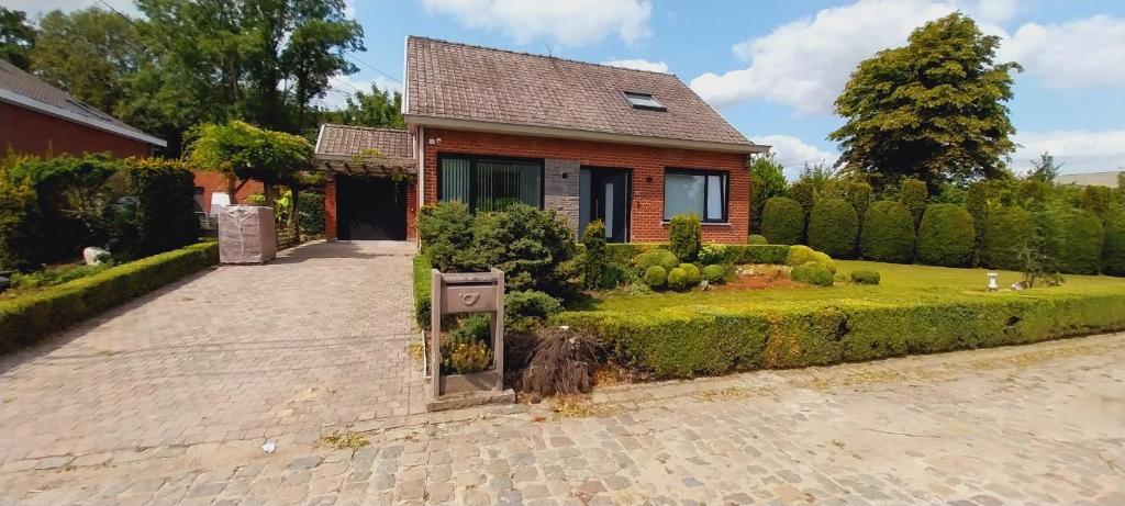 a brick house with a garden and a driveway at Holiday Home Villa Zonnebeke in Zonnebeke