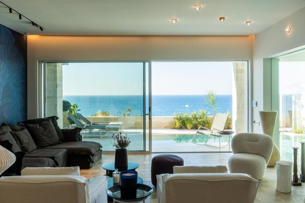 ein Wohnzimmer mit Blick auf das Meer in der Unterkunft My Cave Blue Iconic Designer Villa by the Sea in Rethymno