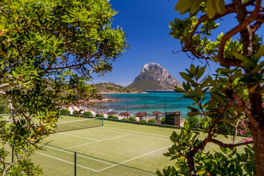 a tennis court on a beach with a mountain at Hotel Don Diego in Porto San Paolo