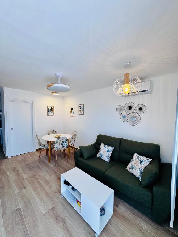 a living room with a green couch and a table at Leo Apartamentos La Cova in Peniscola
