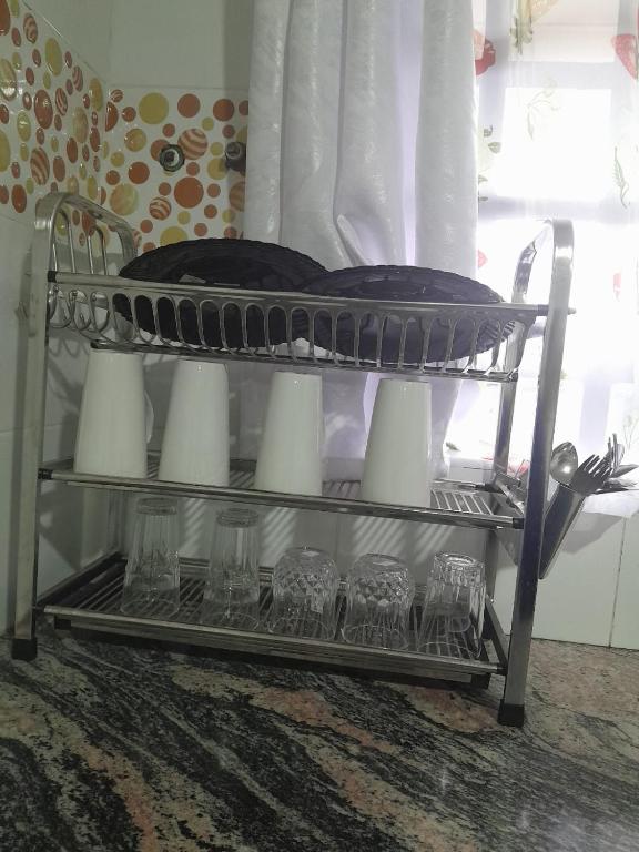 a metal shelf with glasses and a plate on it at Stays by Karen in Nanyuki