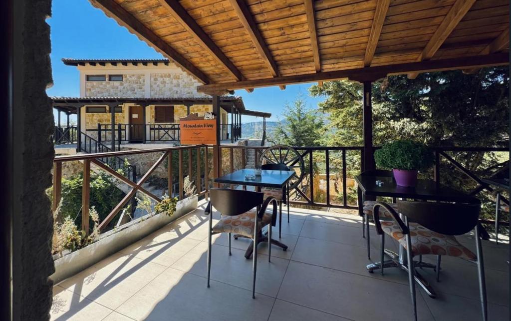 un patio con tavoli e sedie su un balcone di Mountain View a Synikia Mesi Trikalon