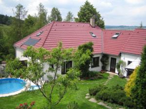 a house with a red roof and a swimming pool at Penzion Nevcehle in Urbanov