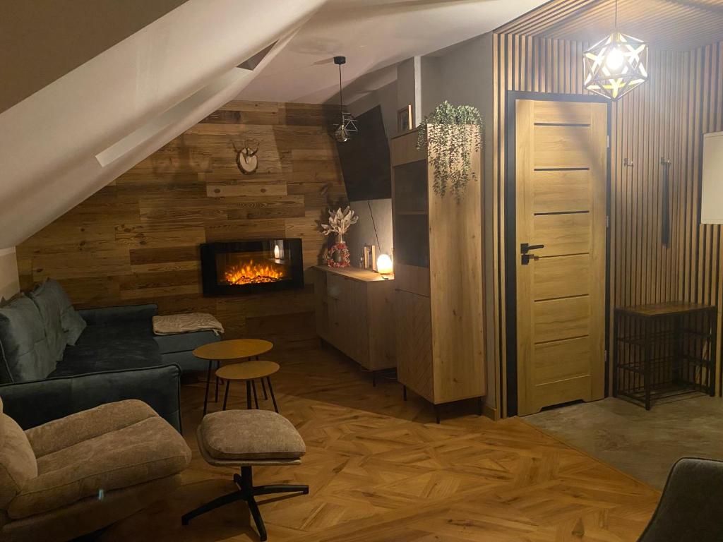 Una sala de estar con un sofá y una chimenea. en Sielsko Anielsko Apartament, en Zawoja