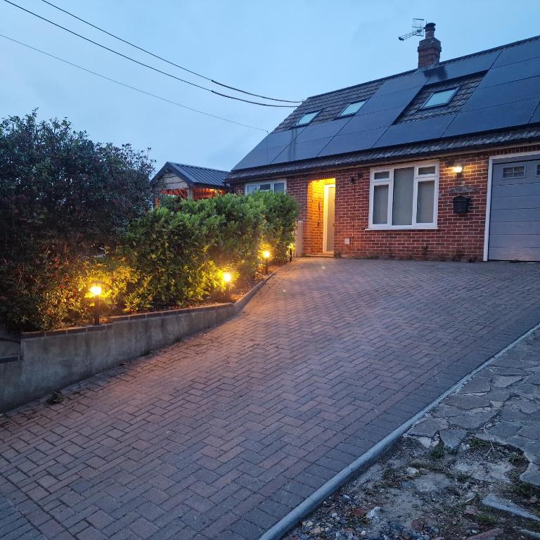 a brick house with a driveway with lights on it at Family-Friendly Bungalow near Salisbury in Alderbury