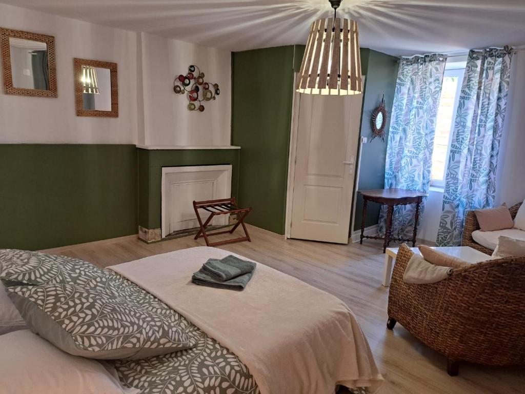 a bedroom with a bed and a couch and a fireplace at La Tanière in Bains-les-Bains
