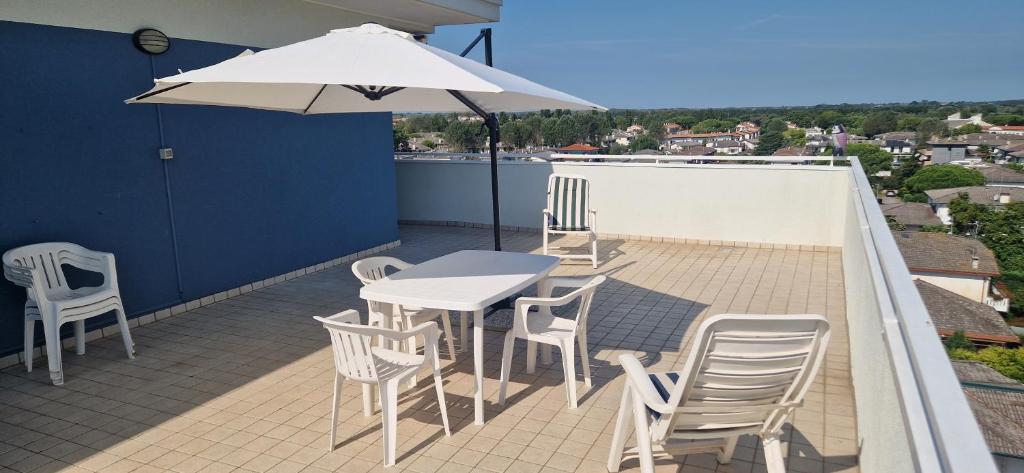 a patio with a table and chairs and an umbrella at Attico Alvorada in Porto Santa Margherita di Caorle