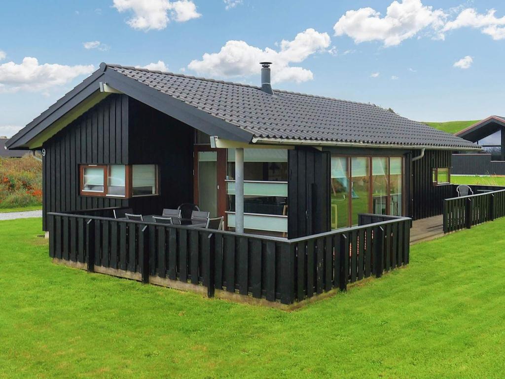 ロンストラップにある8 person holiday home in Hjørring-By Traumの前に柵を持つ黒家