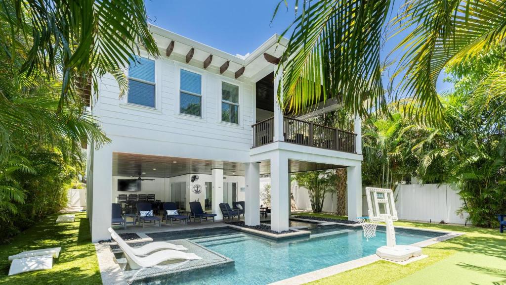 een villa met een zwembad en een huis bij Oar House in Anna Maria