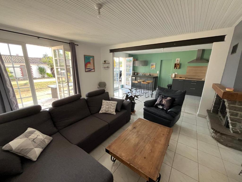 a living room with a couch and a table at Sérénité Marais-Océan in Longeville-sur-Mer
