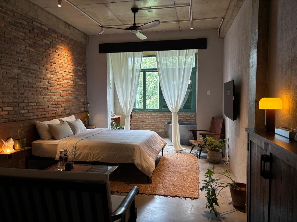 a bedroom with a bed and a brick wall at PREEZE boutique stay in Vung Tau