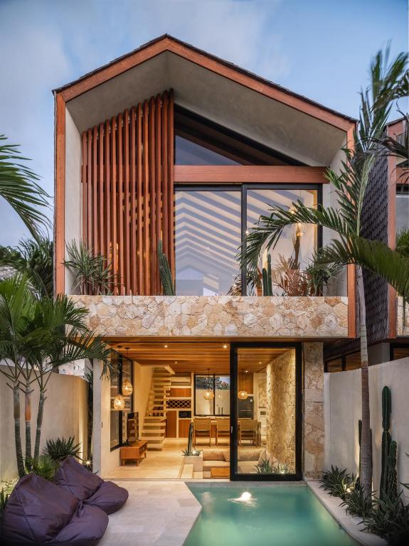 an exterior view of a house with a swimming pool at Blacksand Villas Bingin, Uluwatu by Sandara in Uluwatu