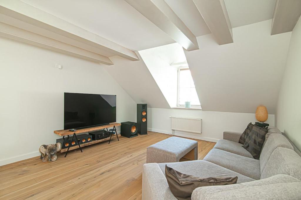 een woonkamer met een bank en een flatscreen-tv bij Spacious 3 BDR apartment in Old Town in Vilnius