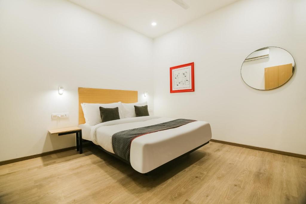 ニューデリーにあるHotel O 7 starの大きなベッドと鏡のある寝室