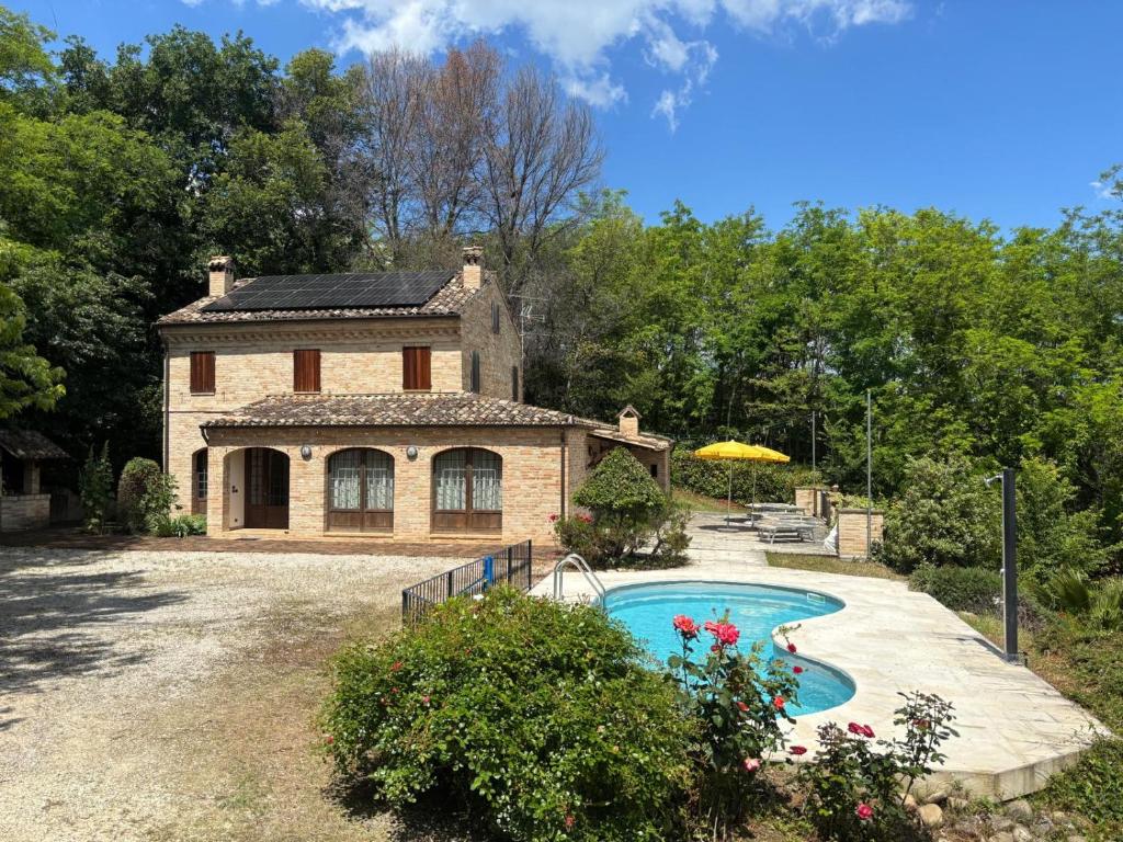 a house with a swimming pool in front of it at Villa Santa Maria in Montegiorgio