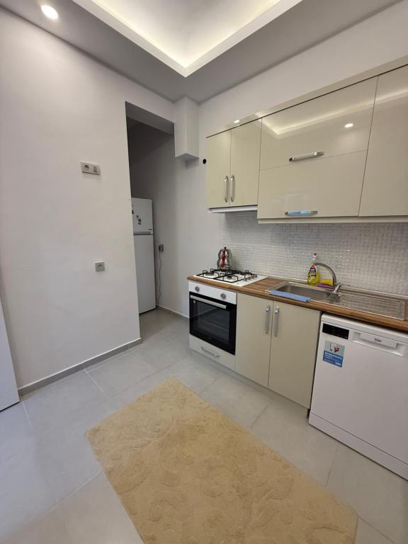 a kitchen with white cabinets and a stove top oven at Ares Vilları in Antalya