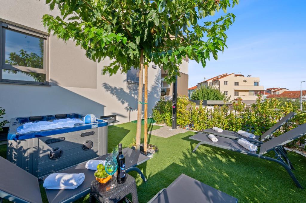 a garden with a tree and a table and chairs at Frida in Vodice