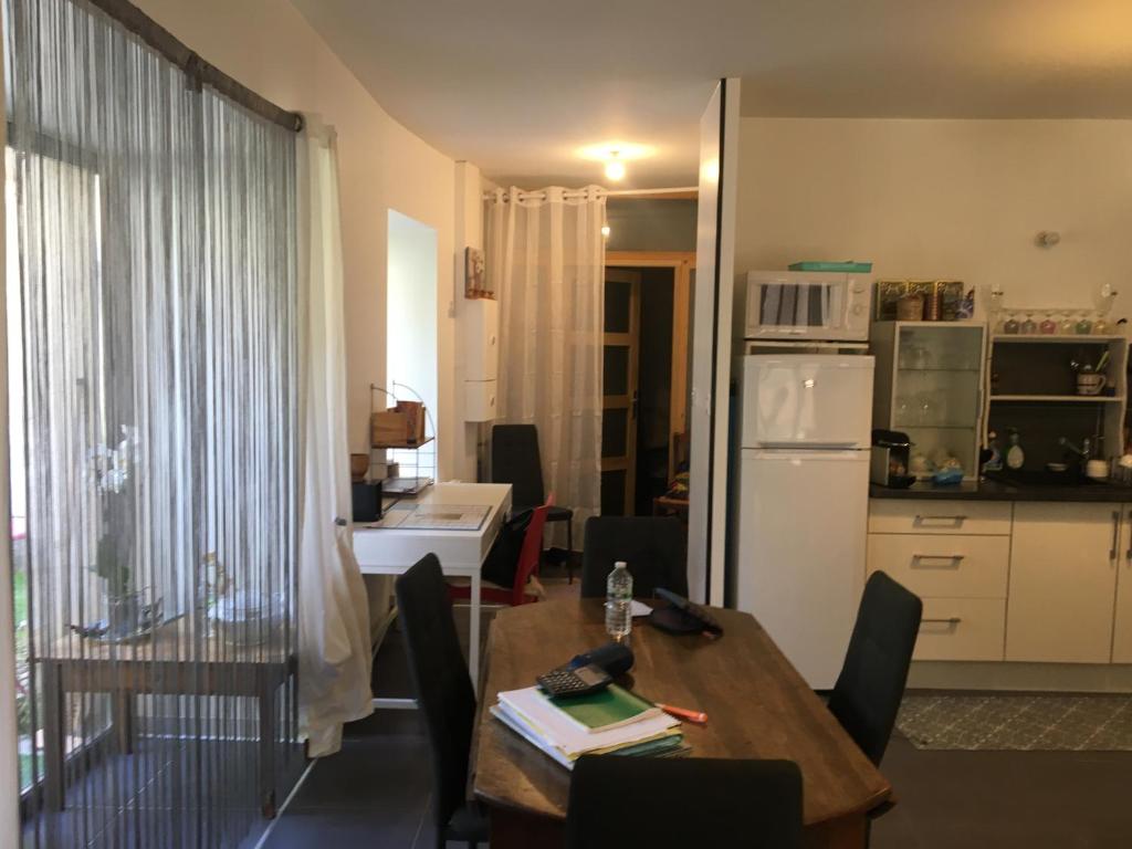 a kitchen and dining room with a table and a refrigerator at La Ruelle in Die