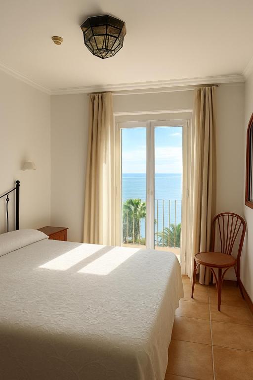 a bedroom with a bed and a view of the ocean at Apartamentos Balcon de Carabeo in Nerja