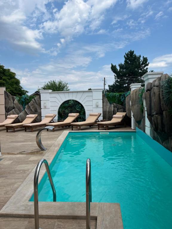 a swimming pool with chaise lounge chairs around it at Soko IN Spa in Soko Banja