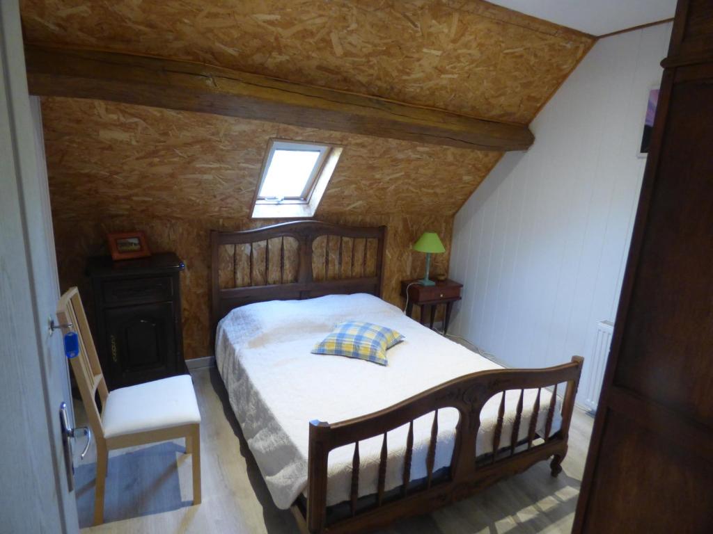una camera da letto con un letto, una finestra e una sedia di les pivoines a Cosges