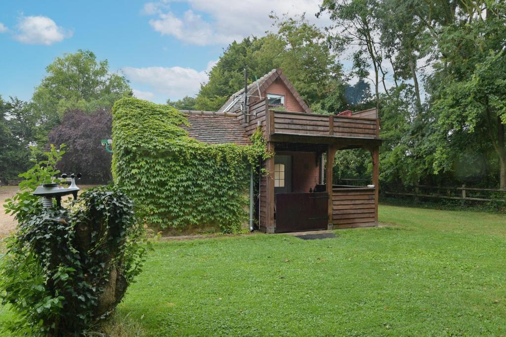 a small house with ivy growing on the side of it at La Maisonnette - Maison atypique à la campagne 