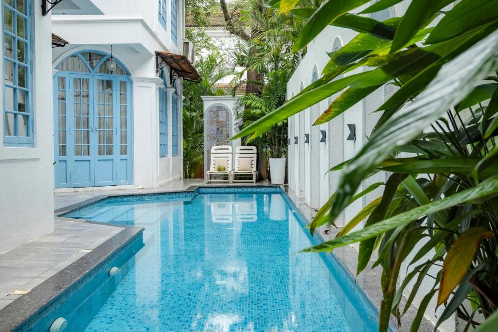 a swimming pool in a villa with a house at Sereno Pearl 3bhk luxury villa with private pool Assagaon in Assagao