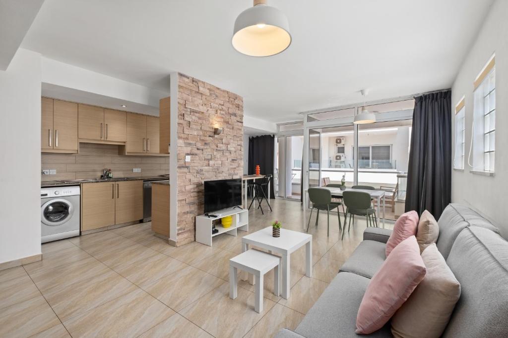 a living room and kitchen with a couch and a table at Giorgio Downtown 2 Bedroom Apartment in Larnaka