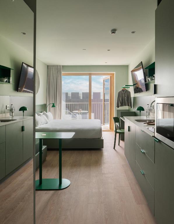 Un dormitorio con una cama y una cocina con ventana. en Kora Kiliki, en Pamplona