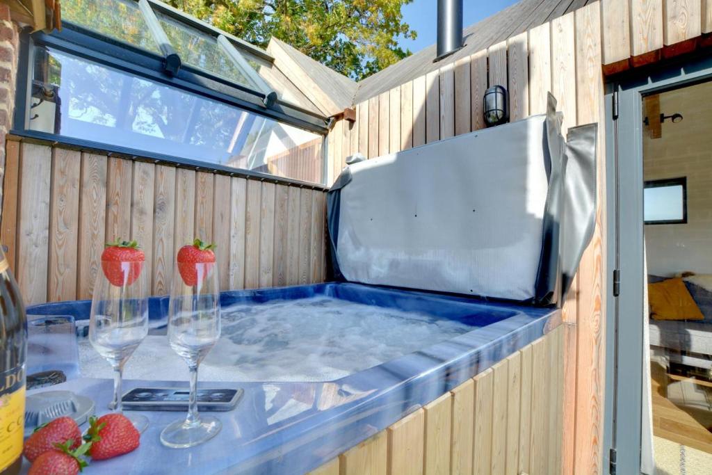 a hot tub with two wine glasses and strawberries in it at The Lookers Legacy in Stone
