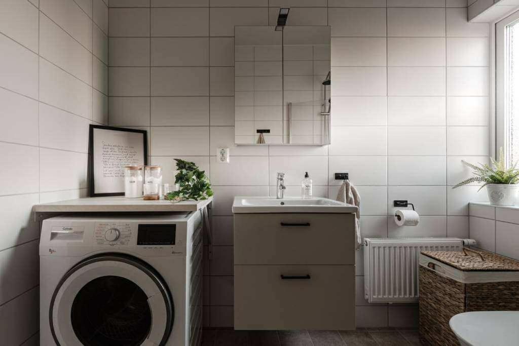 a bathroom with a washing machine and a sink at Lägenhet mitt i Kungshamn in Kungshamn