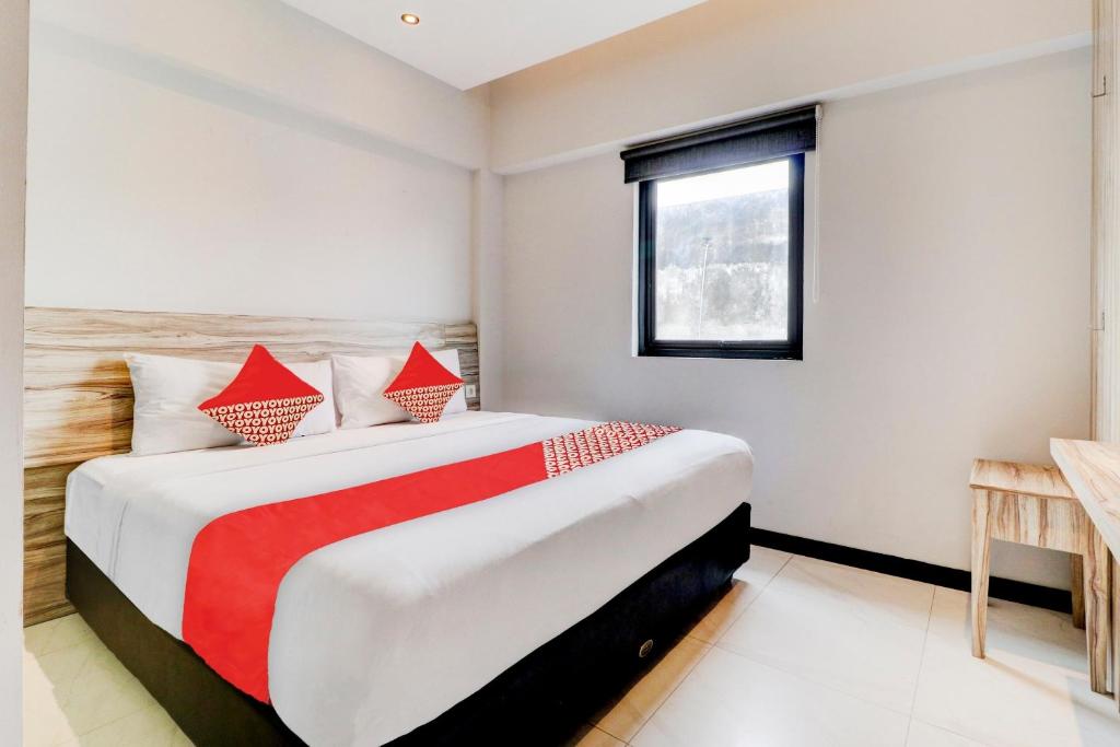 a bedroom with a large bed with red accents at OYO 94728 Isleep Ciwalk in Bandung