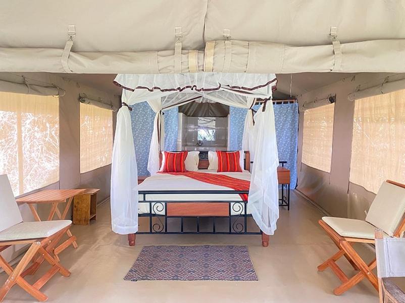 a bedroom with a canopy bed in a tent at Mara Sidain safaris in Sekenani