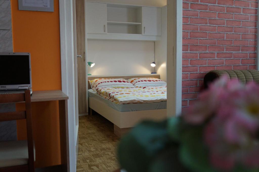 ein kleines Schlafzimmer mit einem Bett und einer Ziegelwand in der Unterkunft Apartment Pokos in Varaždinske Toplice